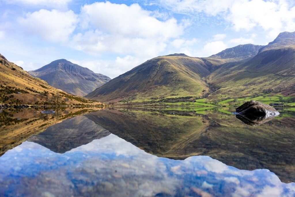 A picturesque landscape of the Lake District, featuring the Cumbrian Mountains and serene lake waters in England's Cumbria region.